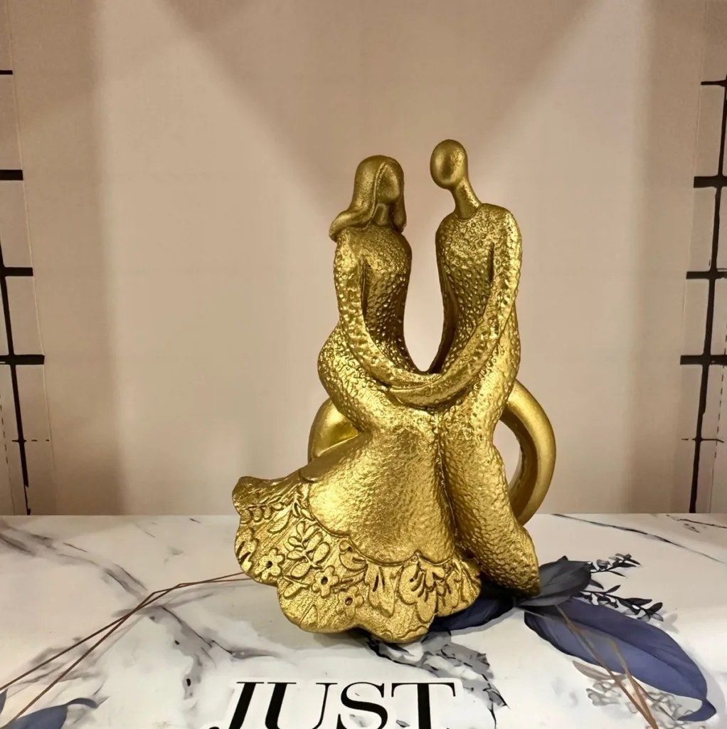Golden couple sculpture holding hands in elegant gold finish