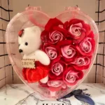 Heart shaped gift box with artificial roses and teddy bear