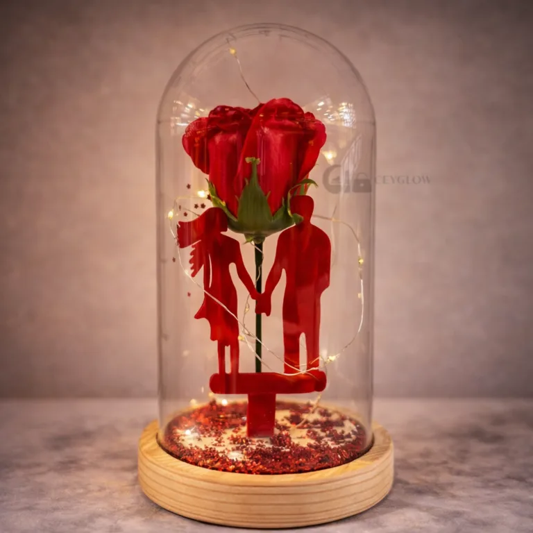 Red artificial rose inside glass dome with warm LED lights and wooden base