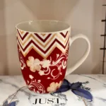 Red floral patterned ceramic mug with handle