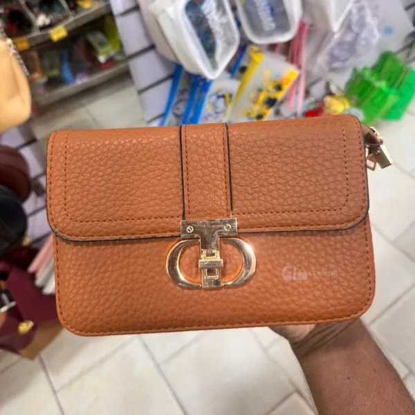 Women's crossbody side bag in pebbled leather texture with gold clasp, available in brown.